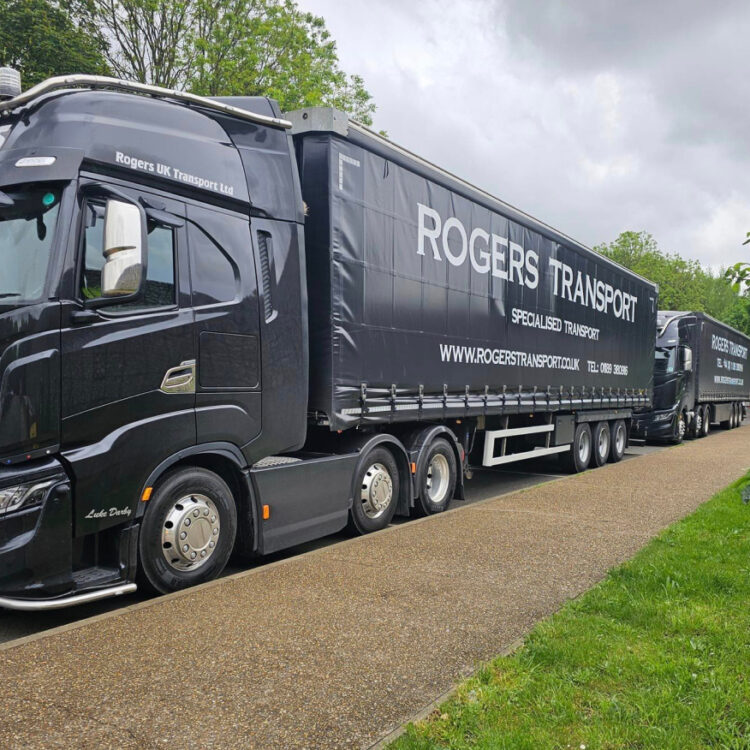 Two black Rogers Transport curtain side outfits parked on a roadway