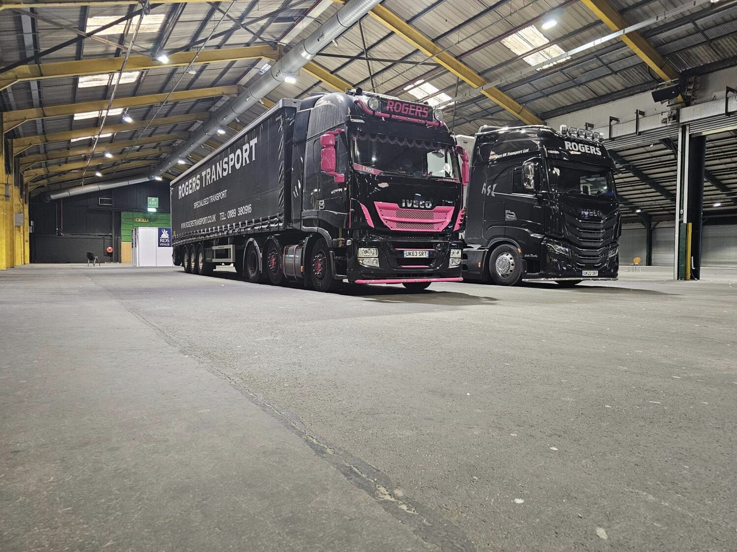 Two Rogers Transport lorries inside an event hall